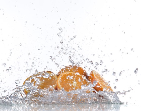 Oranges with water splash isolated on whiteの写真素材
