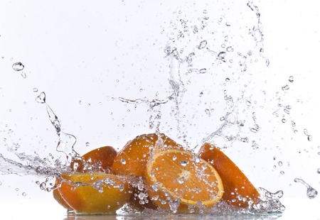 Oranges with water splash isolated on whiteの写真素材