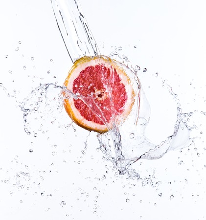 Grapefruit with water splash isolated on whiteの写真素材