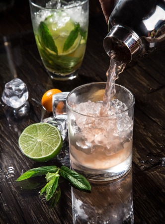 Pouring a cocktail into glass, close-up の写真素材