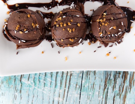 Ice cream scoops on wooden table, close-up の写真素材