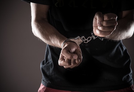 Man handcuffed hands, close-up.