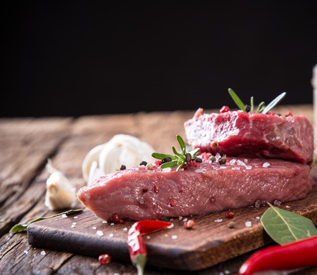 Raw beef steak on wooden table, close-upの写真素材