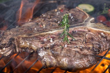 Delicious beef t-bone steak on garden grill, close-upの写真素材