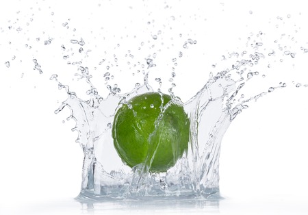 Limes with water splash isolated on whiteの写真素材