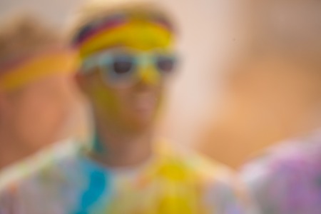 Close-up of marathon, people covered with colored powder, defocused.