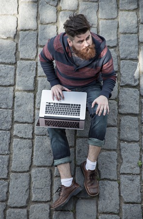 Handsome big moustache hipster man in the city with notebook.の写真素材