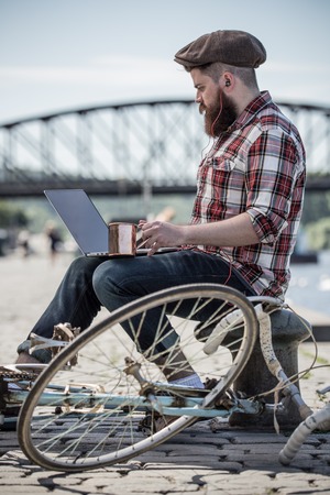 Handsome big moustache hipster man in the city with notebook.の写真素材