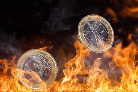 Euro coin with fire flames isolated on black background.の写真素材