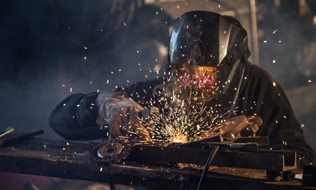 Working welder in action with bright sparks.