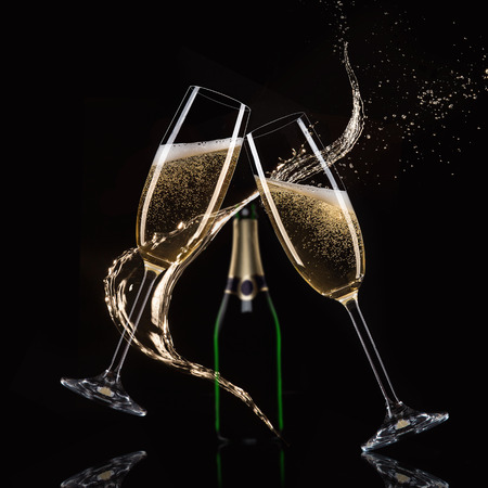 Glasses of champagne with splash, isolated on blackの写真素材