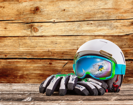 Colorful ski glasses, gloves and helmet on wooden table. Winter ski theme.の写真素材
