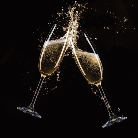 Glasses of champagne with splash, isolated on blackの写真素材