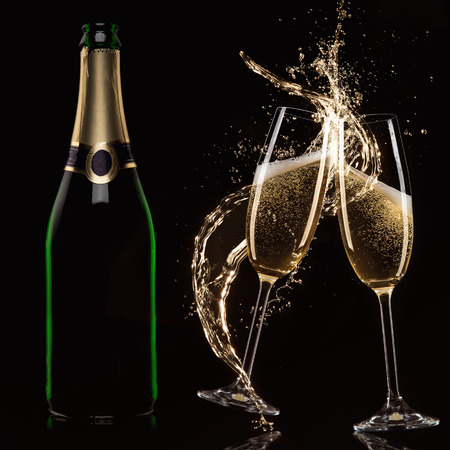 Glasses of champagne with splash, isolated on blackの写真素材