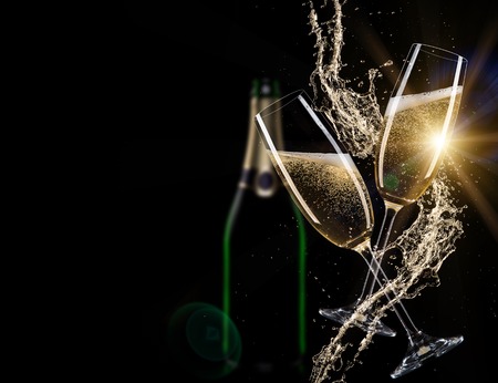 Glasses of champagne with splash, isolated on blackの写真素材