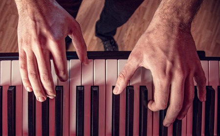 Man's hand playing piano. Close-up.の写真素材