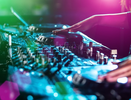Dj mixes the track in the nightclub at party, close-up.