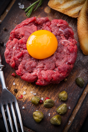 Close up of beef tartar with capers and small toasts.の写真素材