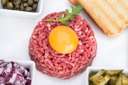Close up of beef tartar with capers and small toasts.の写真素材