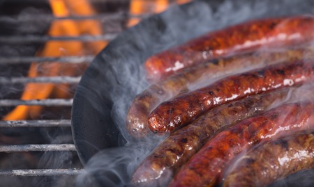 Grilling sausages on barbecue grill, close-up.の写真素材