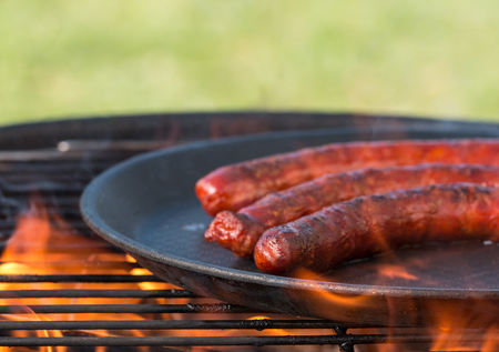 Grilling sausages on barbecue grill, close-up.の写真素材