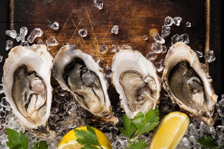 Fresh oysters on a black stone plate top view
