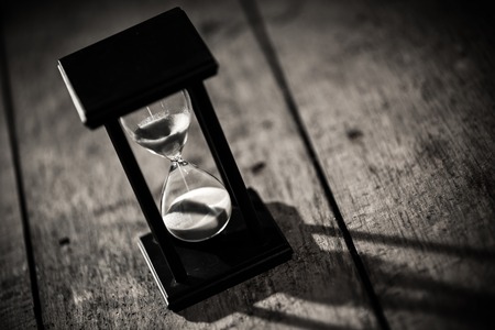 Close-up Hourglass on old wooden background.の写真素材