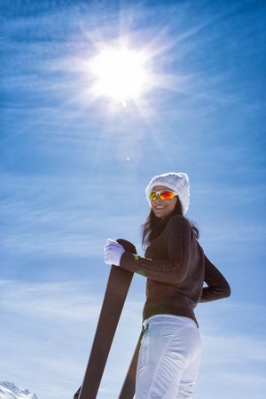 Beautiful brunette woman with skiの写真素材