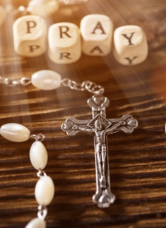 Closeup of iron Christian cross on wooden table.の写真素材