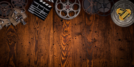 Cinema concept of vintage film reels, clapperboard and projector on old wooden background.の写真素材