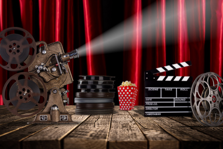 Cinema concept of vintage film reels, clapperboard and projector ond old wooden background.の写真素材