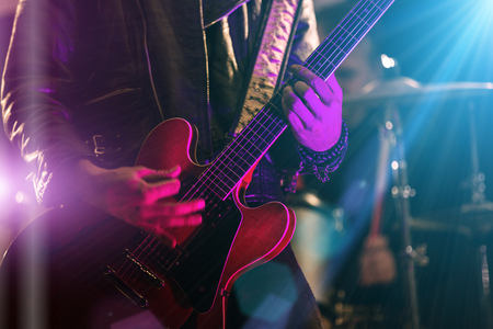 A rocker is playing guitar on stage.