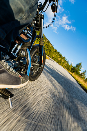 Motorcycle driver riding in Alpine highway, Nockalmstrasse, Austria, central Europe. Nontraditional back side view.の写真素材