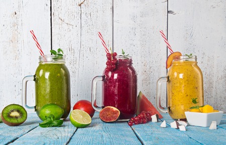 Healthy fresh smoothies with ingredients on old wooden table.の写真素材