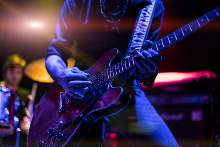 A rocker is playing guitar on stage.の写真素材