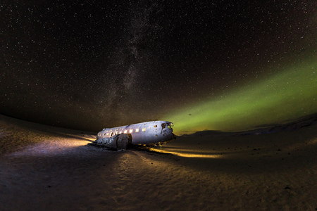 Solheimasandur plane wreck with active norhtern lights, Iceland.の写真素材