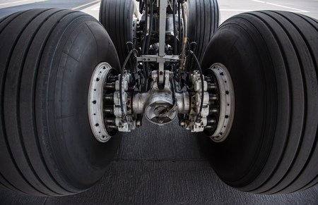 Close-up of main landing gear of modern commercial airplane standing at international airport.