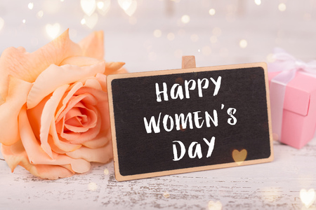 Small chalkboard for Womens day. Background with pink roses.