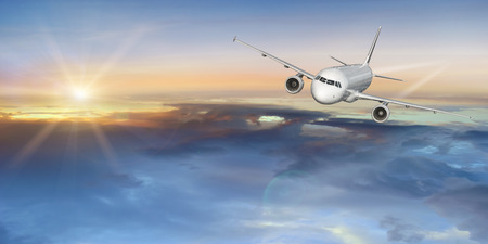 Commercial airplane flying above clouds.