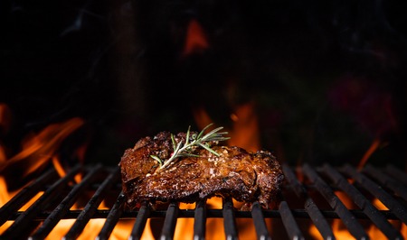 Beef steaks on the grill with flames