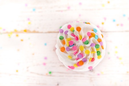 Colorful cup cake on wooden background.の写真素材