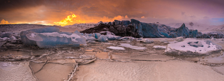 Famous Fjallsarlon glacier and lagoon with icebergs swimming on frozen water.