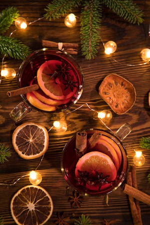 Christmas hot mulled wine with spices on wooden background.の写真素材
