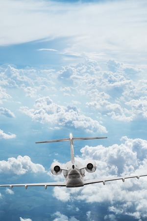 Small private jetplane flying above beautiful clouds.