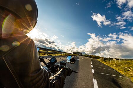 Motorcycle driver riding in Alpine highway, handlebars view, Austria, Europe.の写真素材