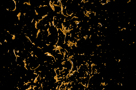 abstract golden liquid splash on black backgroundの写真素材