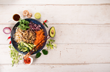 Bun bo nam bo asian food background with various ingredients on wooden table.