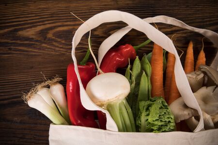 Fresh vegetables in bio eco cotton bags on old wooden table.の写真素材