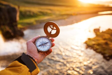 Beautiful landscape with old compass on traveler's hand. Traveling concept.の写真素材