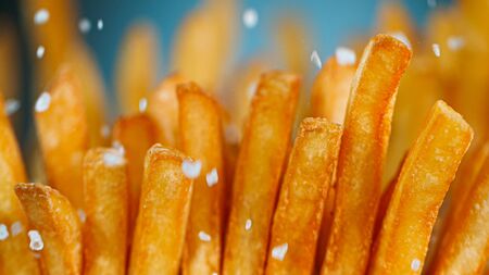 Freeze Motion Detail Shot of adding Salt on French Fries